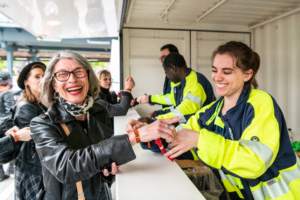 Das Bild zeigt die Einlass-Situation während der Hamburg Harley Days. Zu sehen sind Mitarbeitende des Einalsspersonals und Besuchende bei ausgelassen positiver Stimmung.